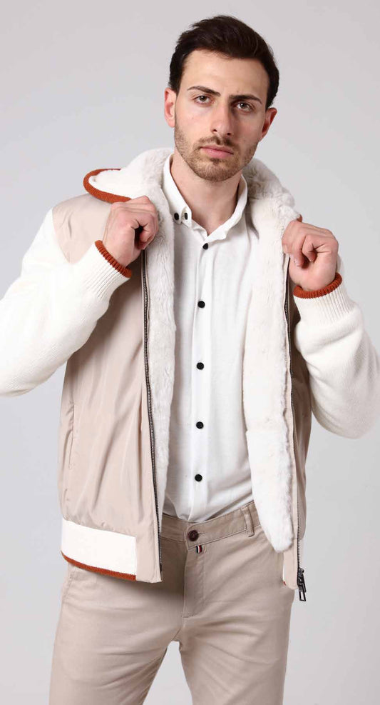 Man wearing a beige jacket with white shirt and beige pants on a light gray background