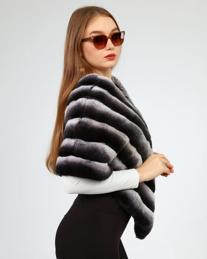 Woman wearing black and gray rex fur over a white top and black pants on a light gray background
