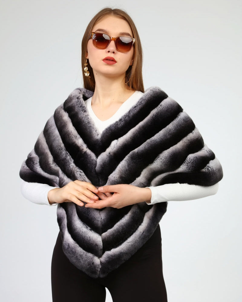 Woman wearing a rex fur gray shawl against a plain background