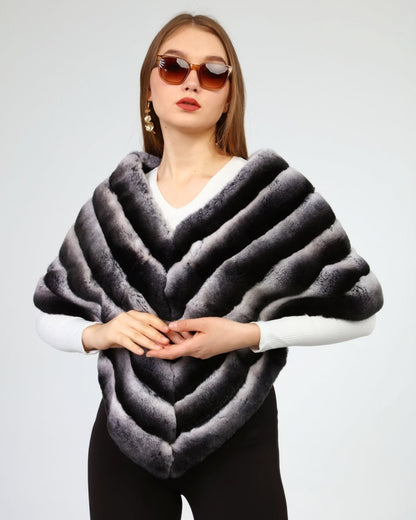 Woman wearing a rex fur gray shawl against a plain background