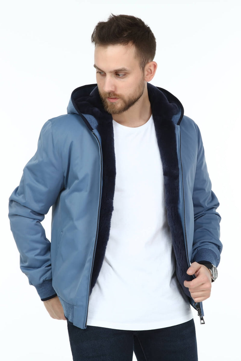 Man wearing a blue jacket with a black hood on a white background