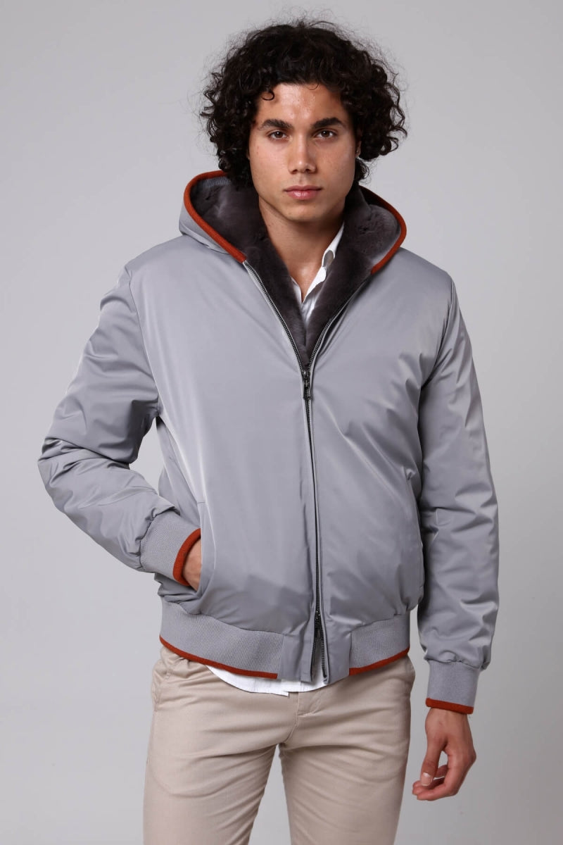 Man wearing a gray jacket with red accents on a plain background