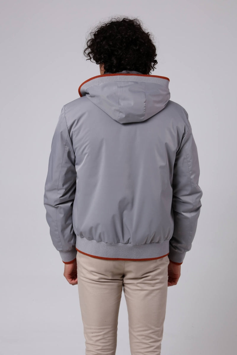 Man wearing a gray jacket with red trim on a white background