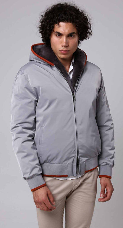 Man wearing a gray jacket with red accents on a plain background