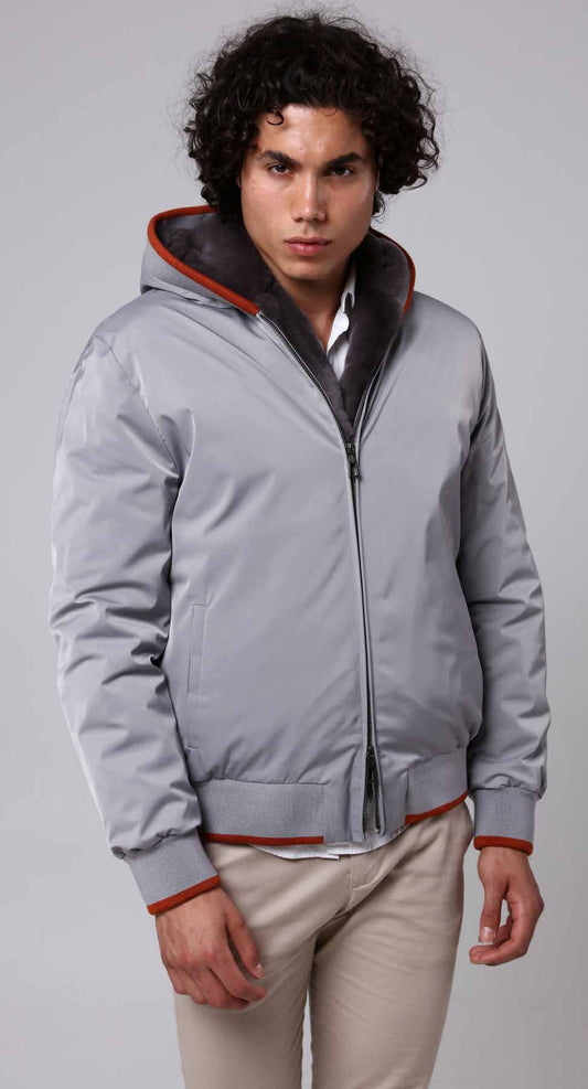 Man wearing a gray jacket with red accents on a plain background