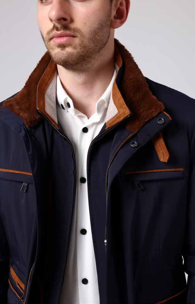 Man wearing a navy jacket with brown accents and a white shirt.