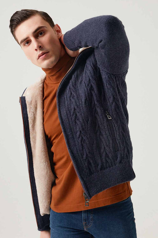 Man wearing a navy cable knit jacket with a beige lining on a white background