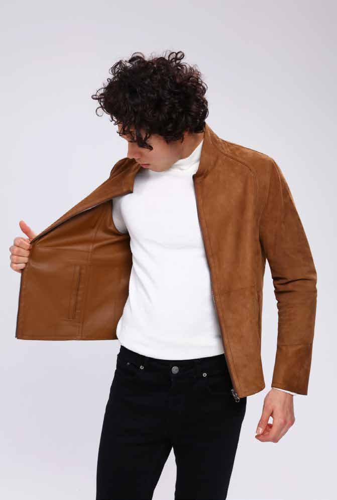 Man wearing a brown leather jacket over a white shirt on a light gray background