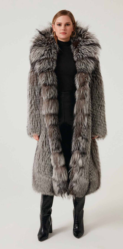 Woman wearing a long fur coat with a hood on a white background