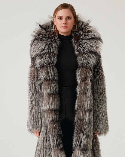 Woman wearing a long fur coat with a hood on a white background