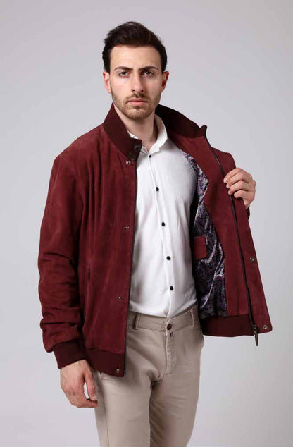 Man wearing a burgundy jacket over a white shirt with a patterned interior lining on a light gray background