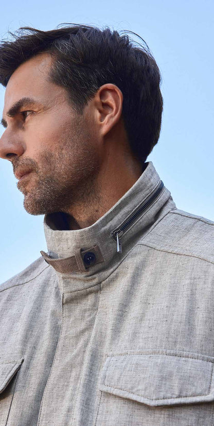 Man wearing a gray jacket against a clear blue sky