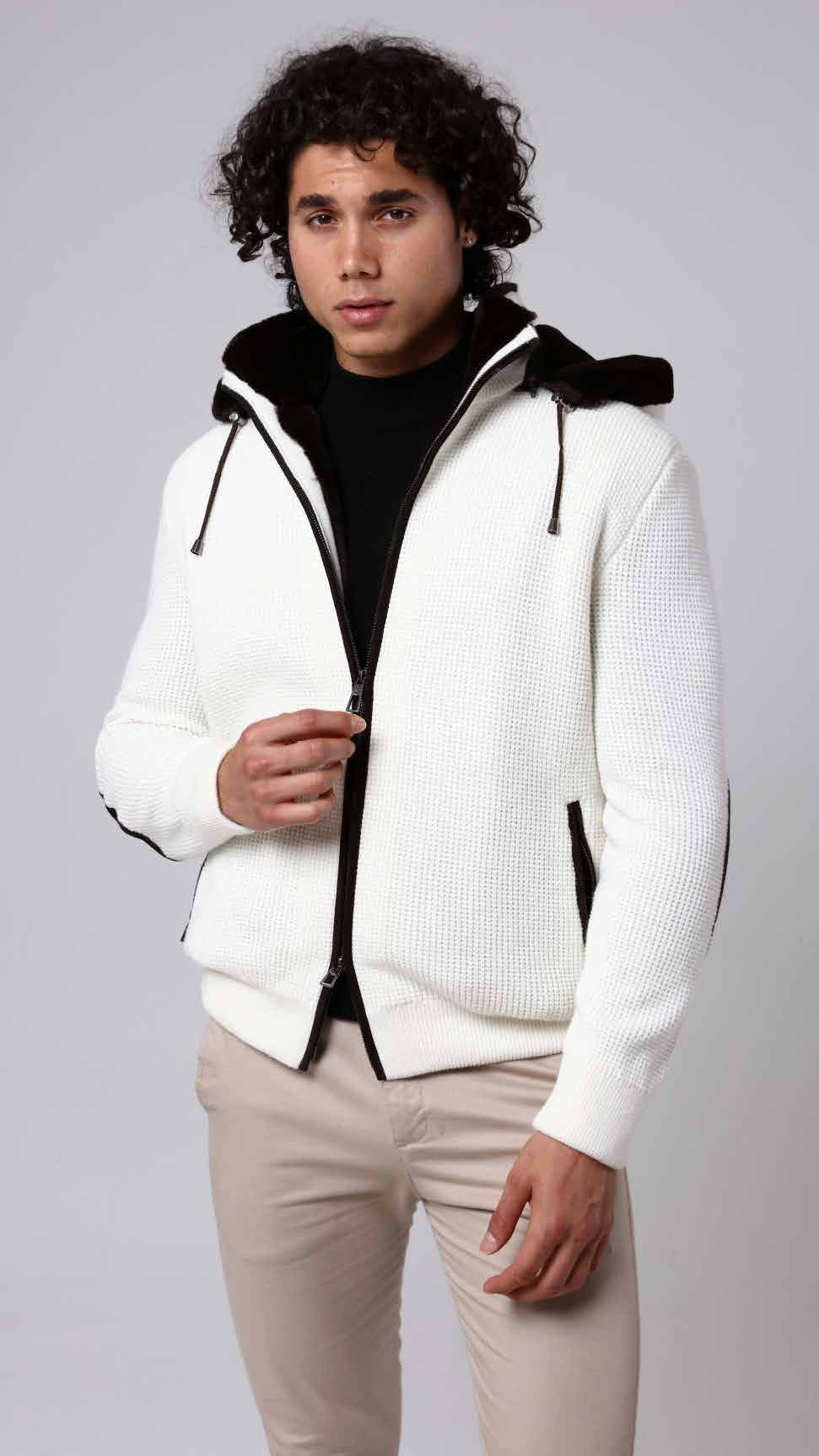 Man wearing a white jacket with black accents on a gray background